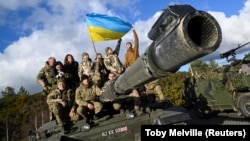 Украинские военнослужащие позируют на танке Challenger 2 на военной базе Bovington Camp на юго-западе Великобритании, 22 февраля 2023 года