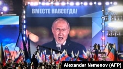 Президент России Владимир Путин (на экране на Красной площади) выступает на митинге и концерте, посвященном аннексии четырех регионов Украины, оккупированных российскими войсками. Москва, 30 сентября 2022 года