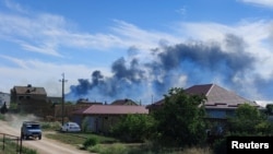 Дым от взрывов на военном аэродроме в поселке Новофедоровка вблизи города Саки в оккупированном Крыму, 9 августа 2022 года