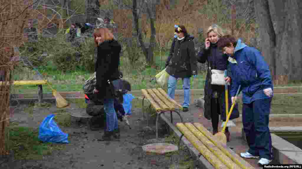 Участники уборки подметали дорожки Горсада выкрашенными в желтый и голубой цвета метлами, убирали мусор в желтые и голубые пакеты. Женщины вплетали в волосы желто-голубые ленты, а мужчины были с флагами Украины.